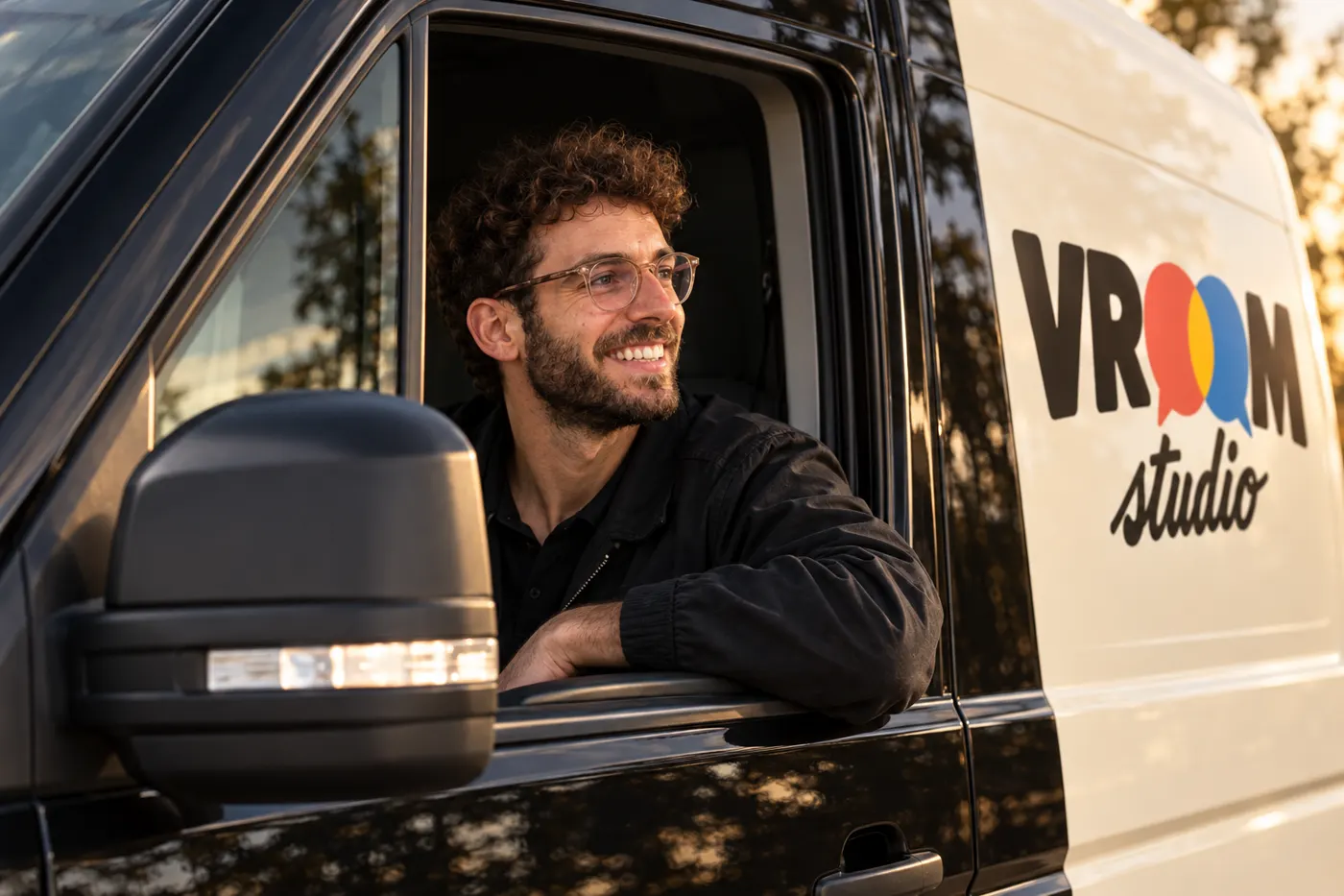 Cyril souriant au volant du camion VROOM studio